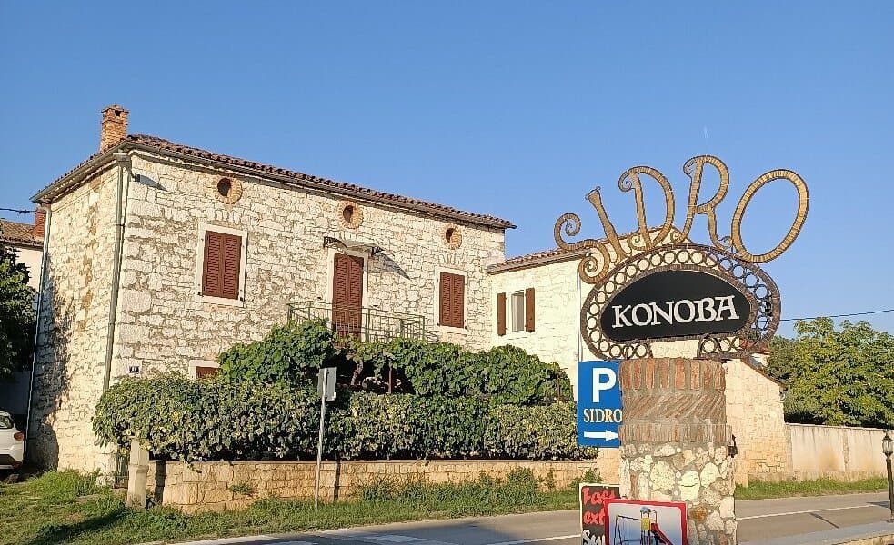 The stone house of Konoba Sidro with its wrought-iron sign