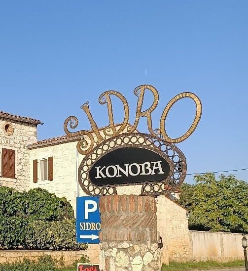 The stone house of Konoba Sidro with its wrought-iron sign